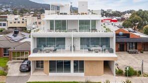 A modern building with a flat roof, large windows, and a balcony. - Dromana Beach Suites - 101 (Dromana)
