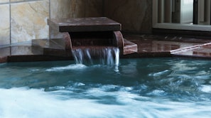 Ein Wellnessbereich mit Wasserspiel und Steinbank.
