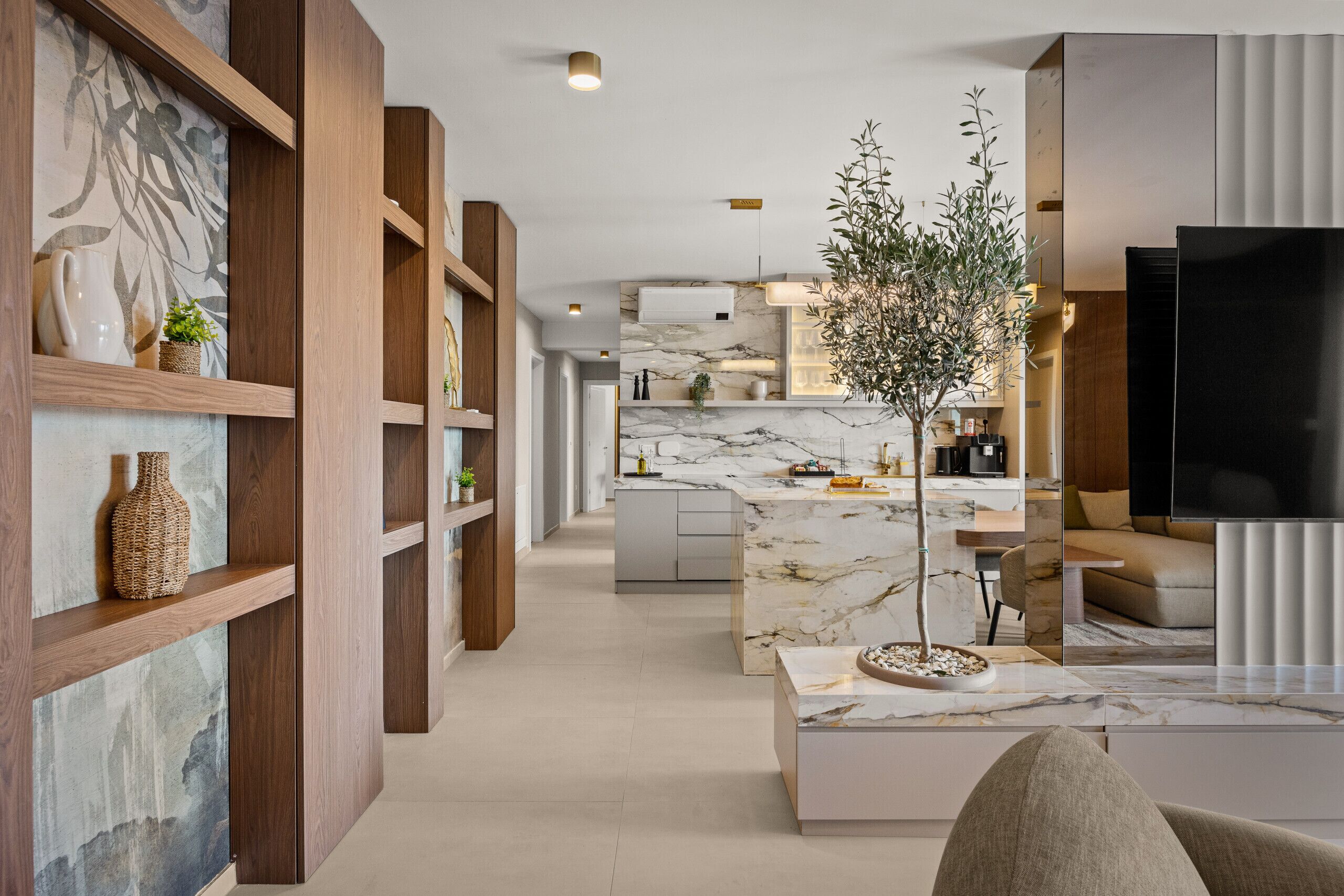 A modern living room with wooden shelves, a marble coffee table, and a large TV.