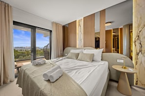 A hotel room with a large bed, a bedside table, a view of the city, and a balcony. - Olive Luxe Penthouse with Jacuzzi and Sea View (Zadar)