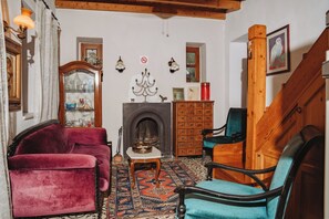 A traditional room with a fireplace, wooden furniture, and a patterned rug.