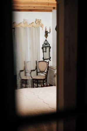 Una habitación con una silla de madera, un espejo y un radiador.