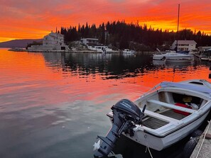 A marina with boats docked, a sunset in the background, and buildings on the shore. - Croatia, Dalmatia! Charming apartment in the fishing village of Blace, right on the water! (Blace)