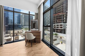A modern room with large windows, a wooden desk, and a chair. - StayShort - 1 Bed in Business Bay that Sleeps 2 with Balcony! (Business Bay)