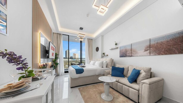 Ein modernes Wohnzimmer mit Sofa, Esstisch, Couchtisch und Blick auf die Stadt.