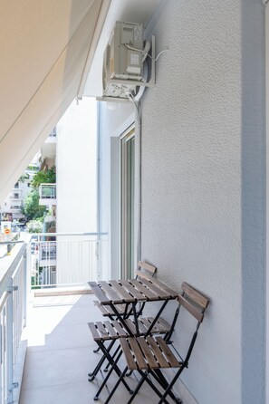A balcony with a row of wooden benches and a white railing. - Charming 2BR Downtown Metro (Athina)