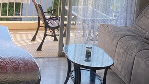 Parveke, josta on näkymä merelle, sohva, pöytä ja tuoli.