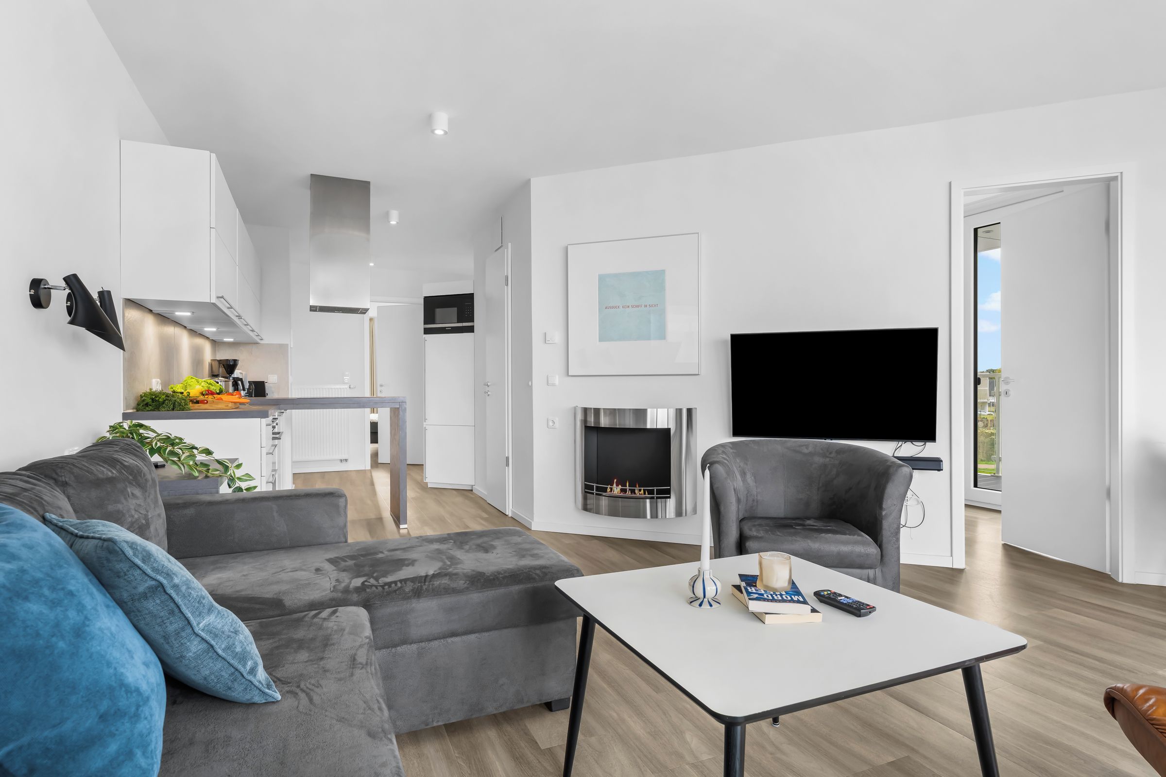 Een moderne woonkamer met een grijze bank, een salontafel en een televisie.