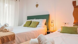 Ein Hotelzimmer mit zwei Betten, einem Nachttisch mit Lampe und einer Wanddekoration in Herzform.