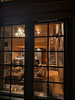 A multi-level interior with a staircase, wooden walls, and a dining area.