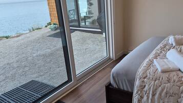 A hotel room with a bed, a window, and a view of a body of water.