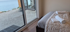 A hotel room with a bed, a window, and a view of a body of water.