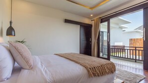 A bedroom with a bed, a hanging light fixture, a view of the outside balcony, and a wooden floor. - Villa Sereine Seminyak (Seminyak)