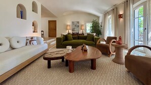 Ein modernes Wohnzimmer mit einem grünen Sofa, einem Holztisch und einem braunen Sessel.