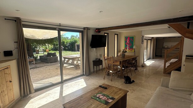 A spacious living room with a large sliding glass door leading to an outdoor area, a wooden coffee table, and a sofa. - A peaceful retreat - pool - 3 min from Lourmarin (Puyvert)