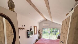 A bedroom with a bed, a bedside table, a mirror, a window, and a door. - A peaceful retreat - pool - 3 min from Lourmarin (Puyvert)