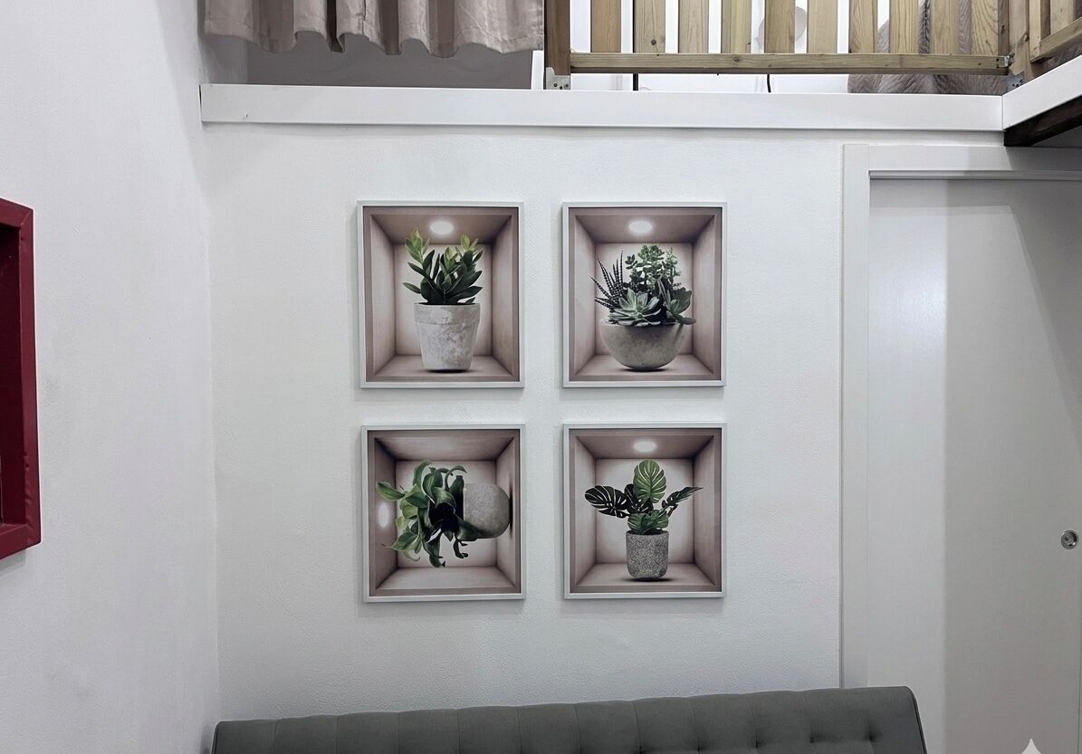 Een muur met vier rechthoekige plantenbakken met diverse planten.