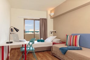 Una camera d'albergo spaziosa con scrivania, sedia, letto e vista dalla finestra.