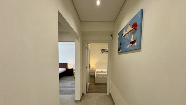 A hallway with a bed and a painting on the wall. - Vilamoura Deluxe 2 With Pool by Homing (Loulé)