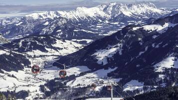 Una stazione sciistica con diversi skilift, montagne innevate e cielo sereno.