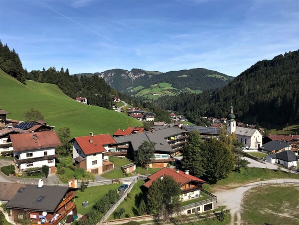Un villaggio con case, una chiesa e una montagna sullo sfondo.