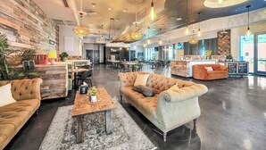 Eine großzügige Lobby mit hoher Decke, mehreren Sitzbereichen und einer Rezeption.