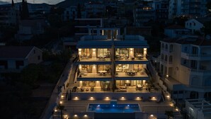 Un edificio de varios pisos con balcones, piscina y vistas al vecindario.