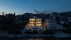 Un hotel frente al mar con un edificio destacado, una piscina y vistas al océano.