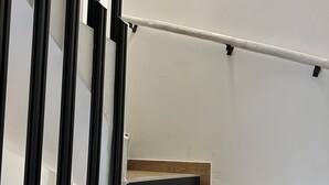 Una escalera con escalones de madera y barandilla metálica.