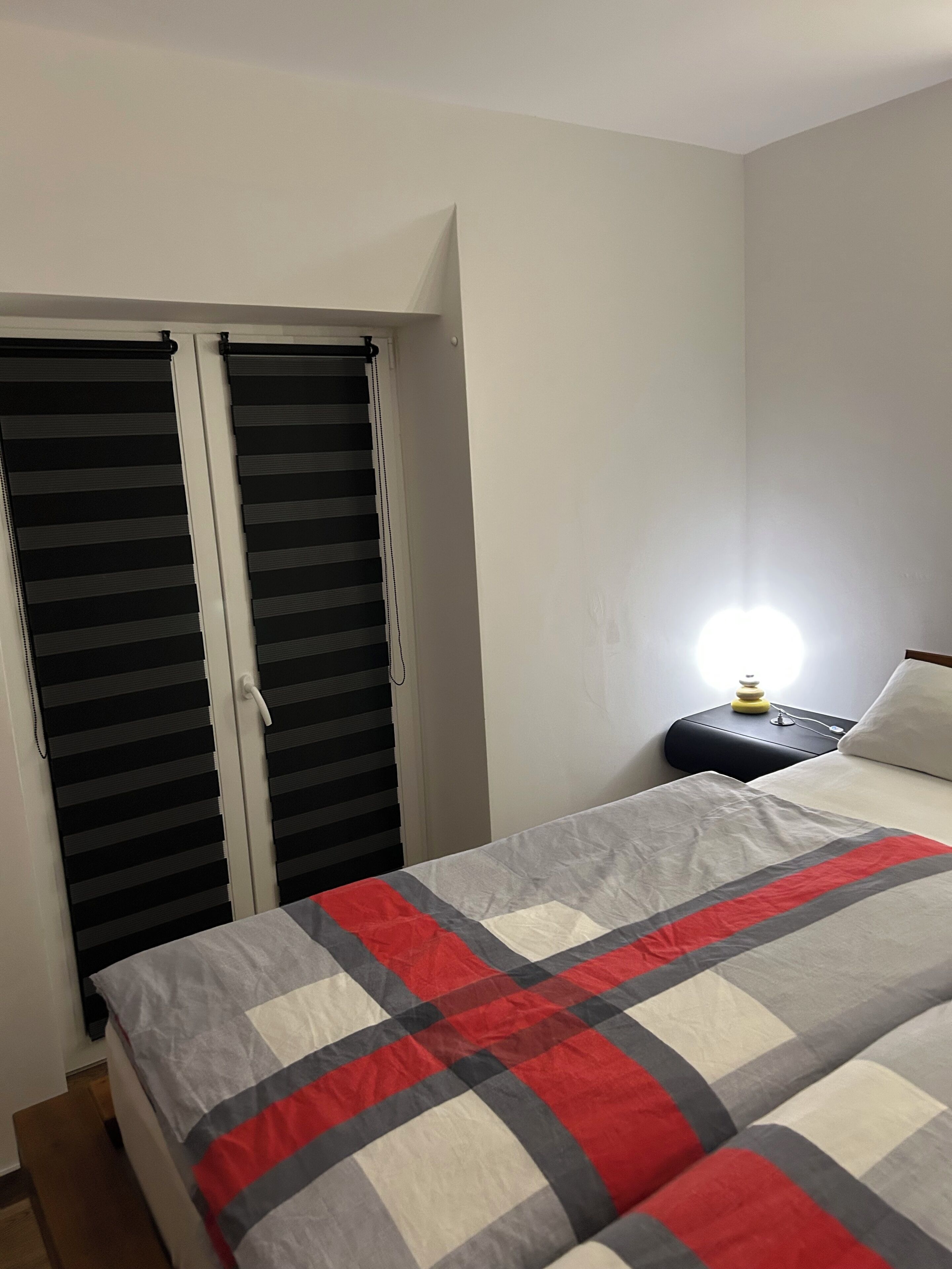 Une chambre à coucher comprenant un lit, une table de chevet, une lampe et une armoire à porte coulissante.