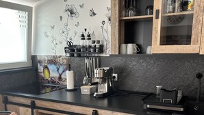 Cocina con armarios de madera, encimera negra y ventana.