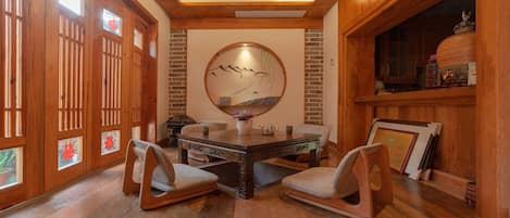 A wooden interior with a dining table, chairs, and a large mirror.