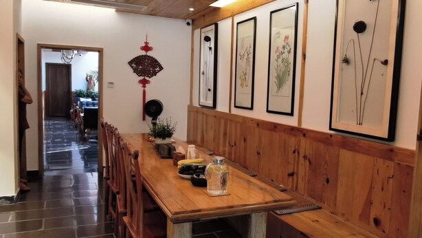 Una mesa de comedor de madera con sillas, una planta en maceta y un adorno de pared.