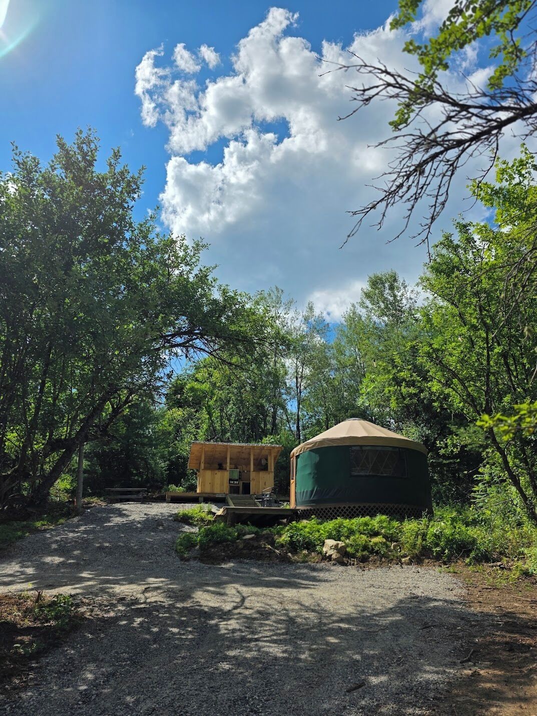 A rustic outdoor setting with a wooden structure and a green tent-like building.