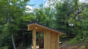 Une structure en bois dotée d’une entrée abritée et d’un chemin de gravier menant à cette entrée.
