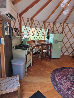 Eine kleine Küche mit Herd, Kühlschrank und Esstisch.