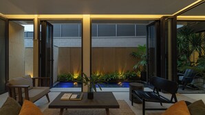 A modern outdoor seating area with a pool, lounge chairs, and a coffee table. - Holiday 3-Bedroom Delightful Villa @ Phan Thiet (Phan Thiết)