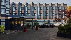 A modern hotel with a geometric facade, a covered entrance, and a paved driveway. - 3 Person Holiday Park Home in Bruehl (Bruehl)