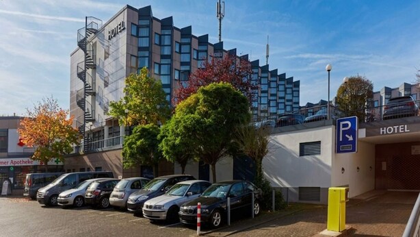 A hotel with a parking area, modern architecture, and a clear sky. - 3 Person Holiday Park Home in Bruehl (Bruehl)