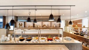 A buffet setup with multiple serving stations, overhead lighting, and a modern interior design. - 3 Person Holiday Park Home in Bruehl (Bruehl)