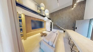 A modern interior with a staircase, a flat-screen TV, and a seating area. - Luxury Garden Duplex Private Jacuzzi (Tel Aviv-Yafo)