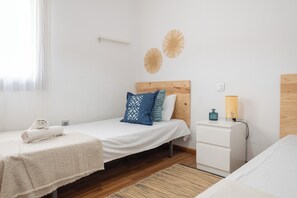 A minimalist bedroom with a wooden headboard, a white bedside table, and a nightstand. - LXR Townhouse, 2 Bedrooms, Near the Ocean (Las Lagunas de Mijas)