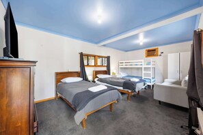 A hotel room with two beds, a TV, a desk, and a wardrobe.