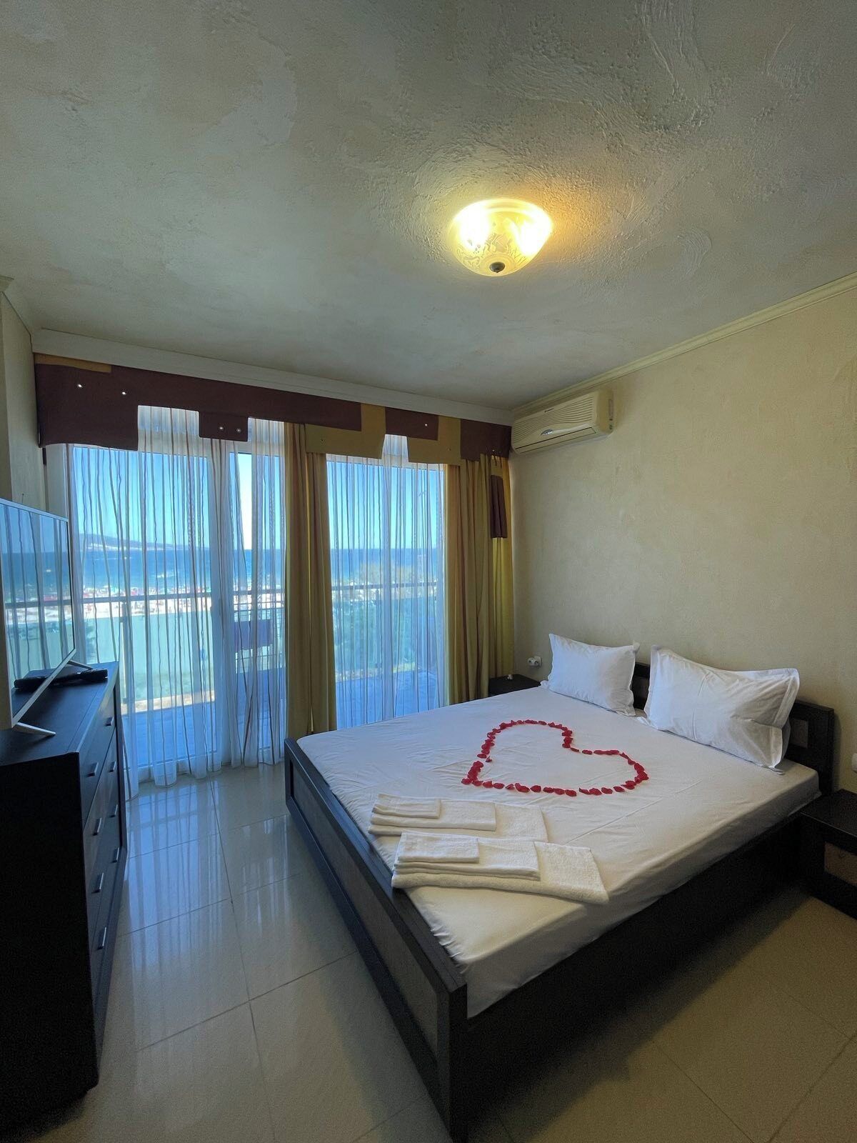 Habitación de hotel con cama, escritorio y vista al mar.