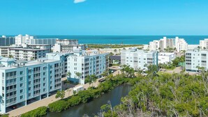 A coastal hotel with multiple buildings, a river, and a clear view of the ocean. - FABULOUS 2B/2B ISLAND CONDO! POOL! WALK TO BEACH! WALK TO EVERYTHING! (Fort Myers Beach)