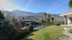Ein Wohnhaus mit Swimmingpool, einer Terrasse und Gartenmöbeln sowie Bergblick.
