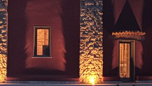 Un edificio con techo de tejas, paredes de piedra y varias ventanas.