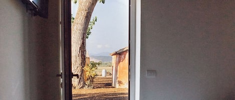 A bedroom with a bed, a window, and a view of the outside.