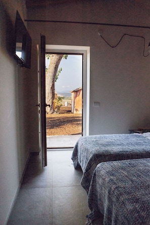 Un dormitorio con cama, ventana y vistas al exterior.