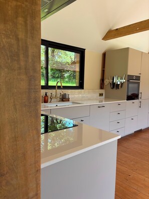 A modern kitchen with a large window, white cabinetry, and a built-in oven. - Gorgeous 3-bedroom house in delightful Tourouvre au Perche (Tourouvre au Perche)